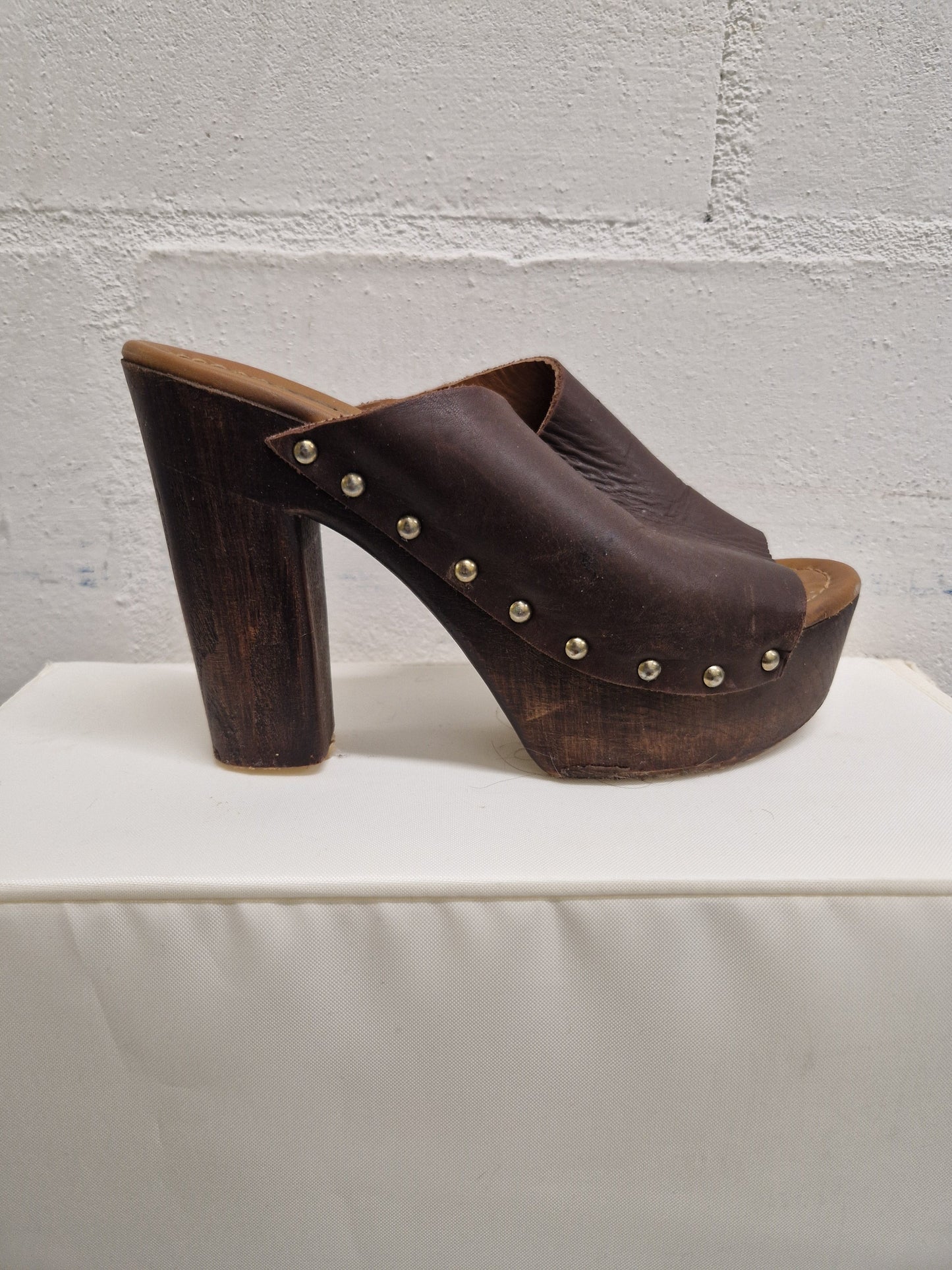 brown chunky heels with small platform. bronze stud detail and open back. damage to the sole.